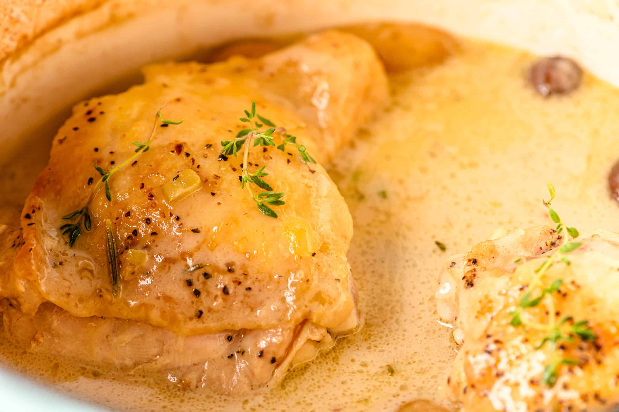 Juicy chicken thighs cooked in a creamy, flavorful sauce garnished with fresh thyme and herbs, perfect for comforting homemade dinner recipes.