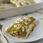 Creamy Turkey Enchiladas with Green Sauce and Crumbled Cheese, served on a white plate. Perfect comfort food for a flavorful Mexican-inspired meal.