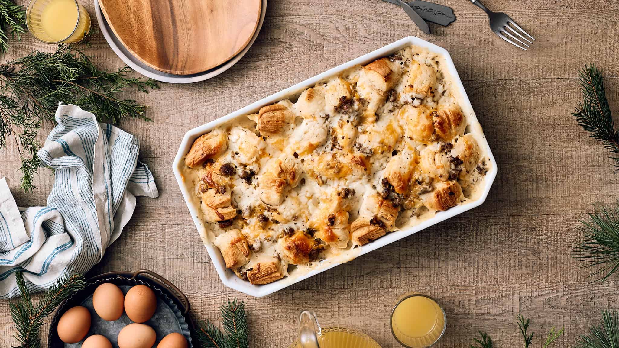 Creamy chicken and mushroom casserole with crispy pastry topped with cheese, served in a white baking dish on a rustic wooden table.