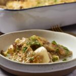 Slow cooker beef stew with tender beef chunks, potatoes, carrots, and peas in rich gravy garnished with chopped parsley. Perfect comfort food for chilly days, easy to make in a slow cooker.
