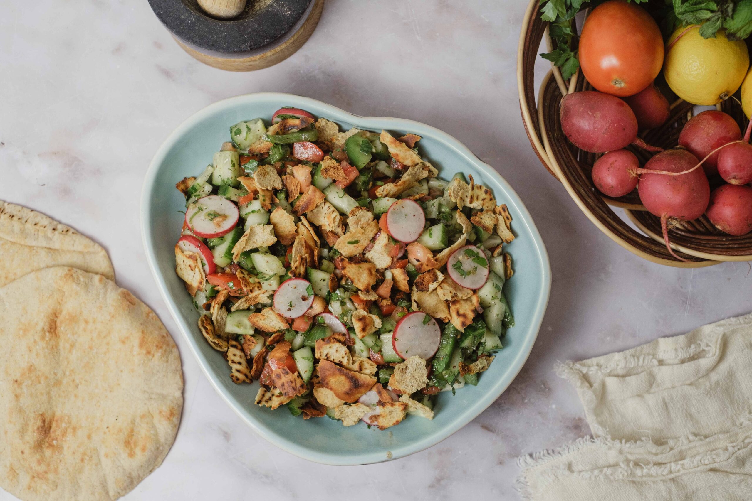 Fresh cucumber and radish salad with crispy pita chips and herbs, served in a white bowl for a healthy, delicious meal.