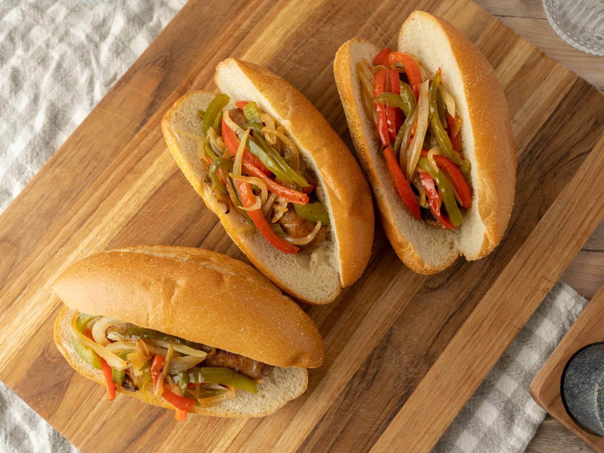 Steamed bao buns filled with colorful stir-fried vegetables including bell peppers and onions, served on a wooden cutting board for a delicious and healthy Asian-inspired dish.