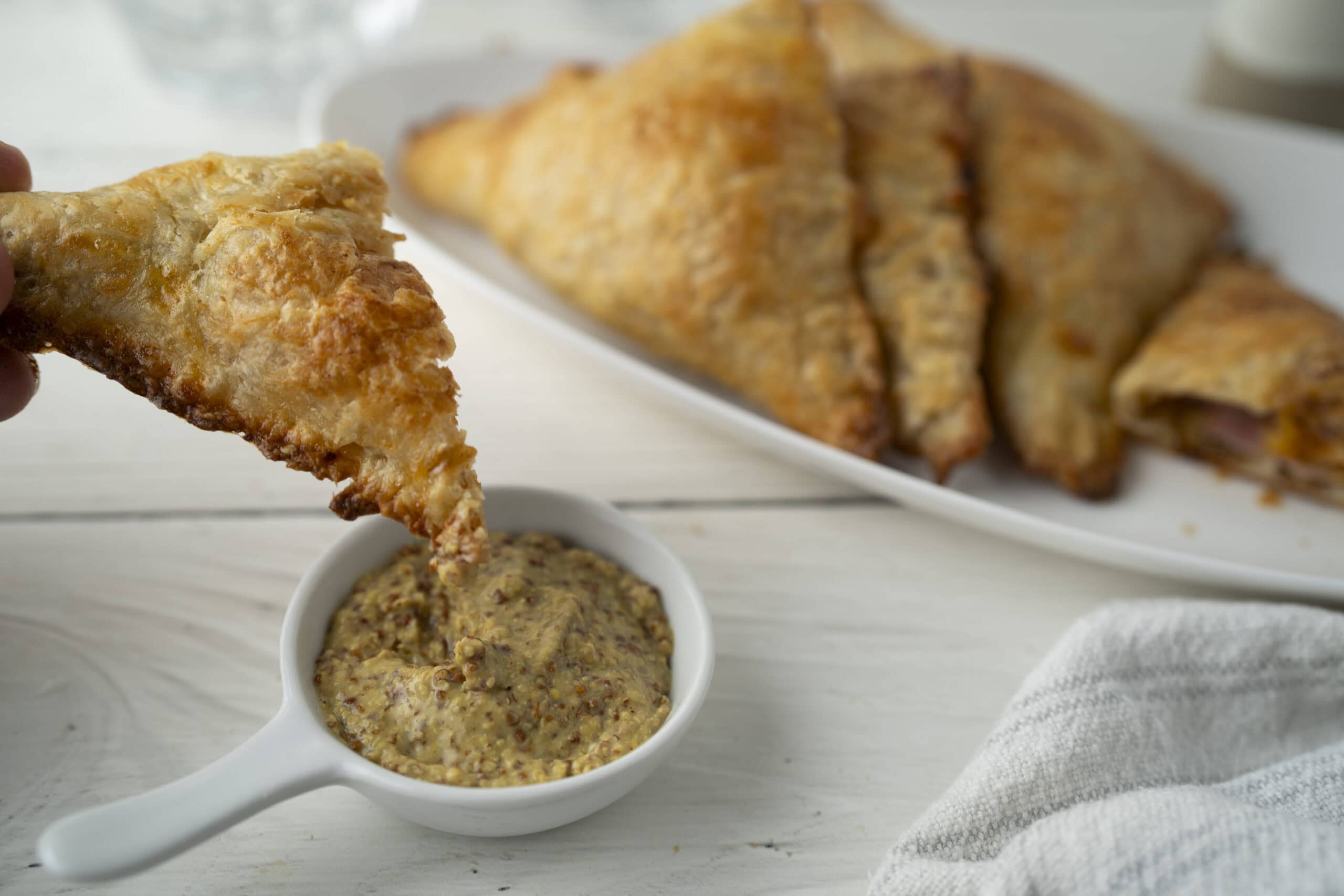 Golden fried chicken served with a side of spicy mustard dipping sauce on a white plate.