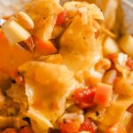 Creamy vegetable pasta soup with tomatoes, carrots, and zucchini, topped with herbs, served in a white bowl. Perfect comfort food for chilly days or easy weeknight dinners.