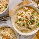 Creamy chicken vegetable soup with shredded chicken, carrots, peas, corn, and green beans served in white bowls. Perfect comfort food for cold days, rich in flavors, and easy to prepare.