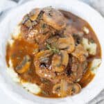 Tender meatballs with mushroom gravy served over creamy mashed potatoes. This classic comfort food dish is perfect for cozy dinners and features savory flavors with fresh herbs.