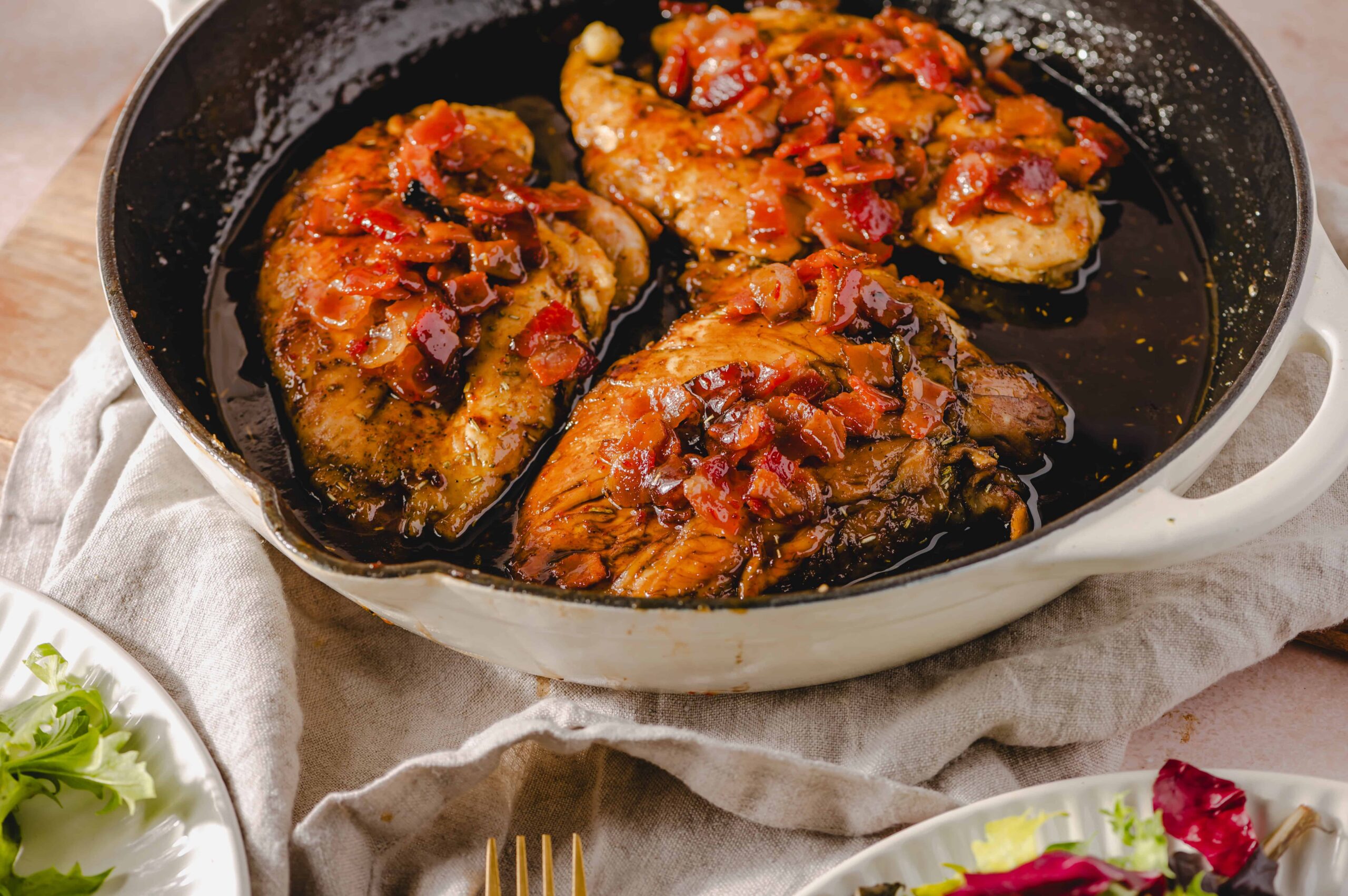 Tender chicken thighs in a rich, savory sauce with chopped tomatoes, served in a white baking dish, garnished with fresh herbs, perfect for a hearty meal, featured on Hey Recipe.