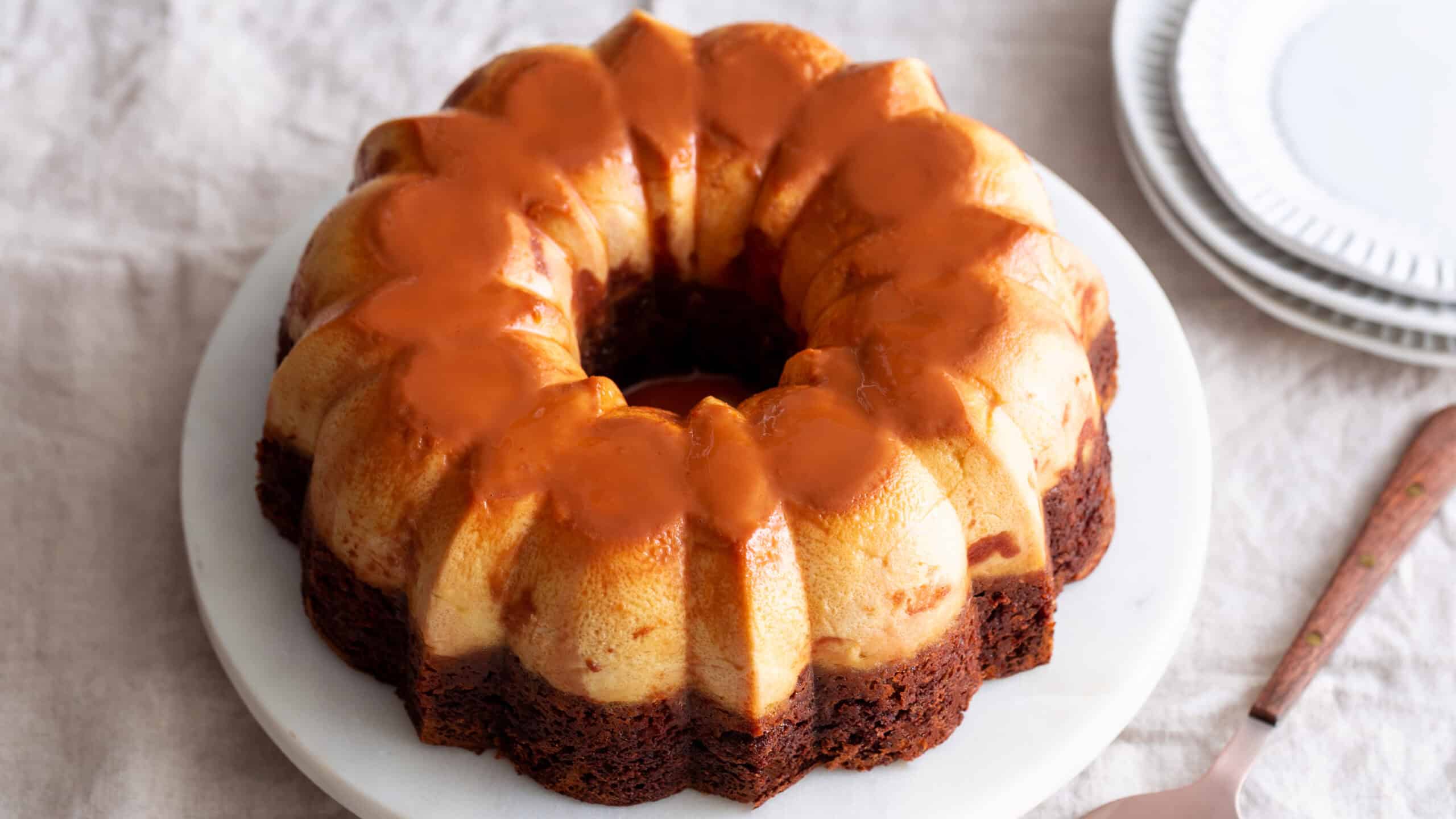 Delicious caramel sauce-glazed bundt cake topped with a rich caramel drizzle, perfect for dessert or special occasions. Moist, flavorful, and beautifully presented on a white plate.