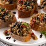 Savory bruschetta topping with chopped vegetables, herbs, and balsamic glaze on toasted bread slices. Perfect appetizer or party snack with fresh ingredients and vibrant flavors.