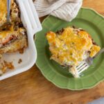 Creamy baked casserole with ground beef, vegetables, and melted cheese served in a green plate, ready to enjoy a comforting meal.