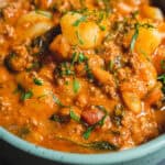 Creamy potato and ground beef curry garnished with fresh herbs in a bowl, featuring a rich, flavorful sauce packed with vegetables and spices. Perfect for hearty Indian-inspired meals.