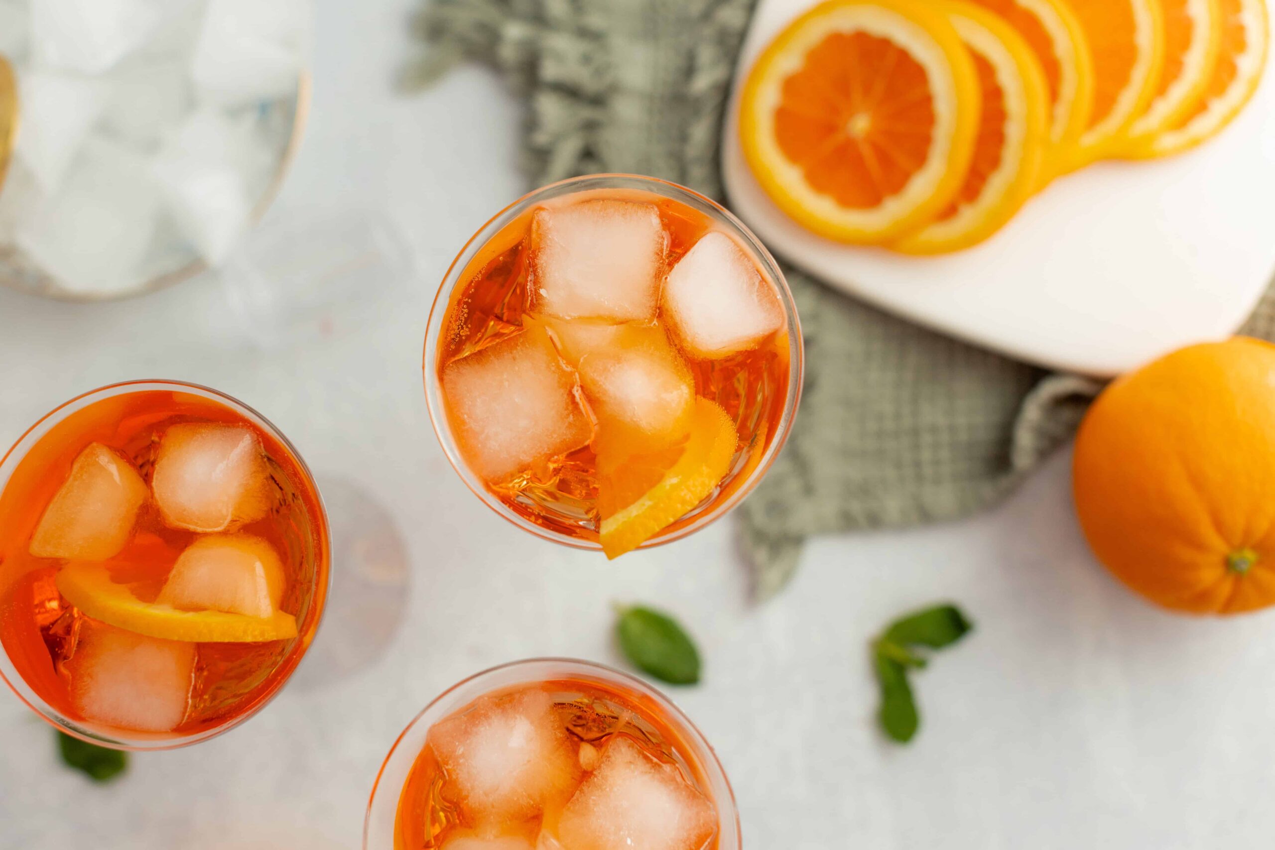 Refreshing orange iced tea with lemon slices and ice cubes, served in clear glasses, perfect for summer beverages and citrus-infused drinks.