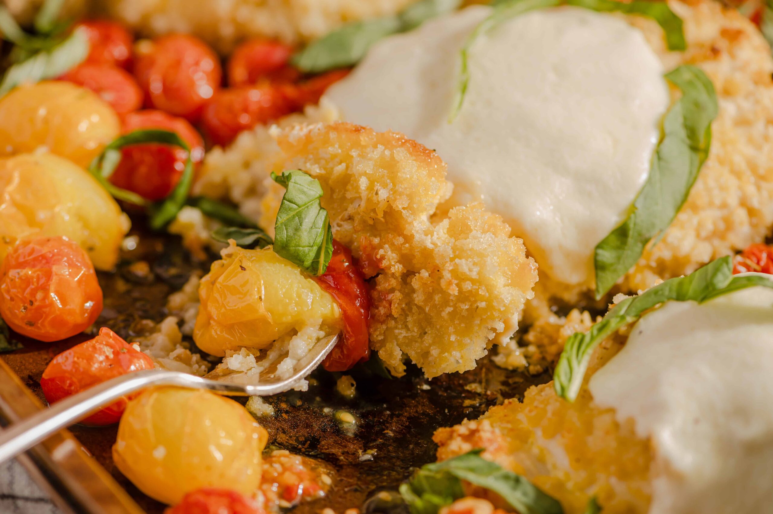Golden fried fish fillet with creamy white sauce, served with roasted cherry tomatoes and fresh basil leaves on a rustic wooden platter. Perfect for seafood lovers seeking delicious, crispy fish recipes.
