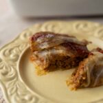 Ground meat casserole with melted cheese and tomato sauce on an ornate vintage plate, served as a savory baked dish, perfect for comfort food and family dinners.