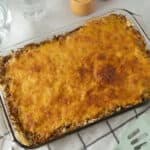Creamy baked ground beef and pasta casserole with melted cheese on top, served in a glass baking dish for family dinner or meal prep.