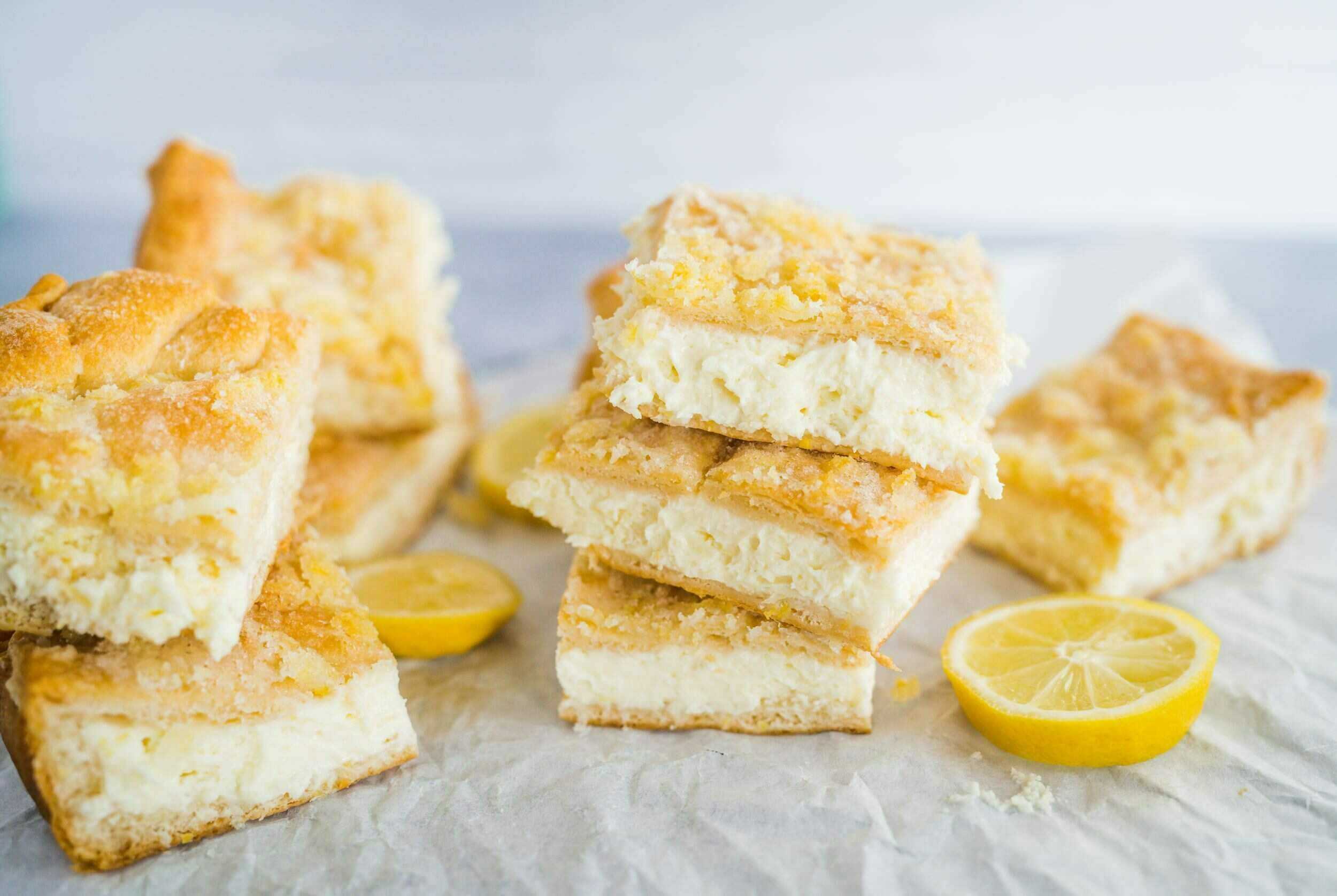 Lemon bars with a buttery crust and creamy lemon filling, garnished with fresh lemon slices, perfect for summer desserts or teatime treats.