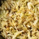 Sautéed shredded cabbage with red pepper flakes, garlic, and spices in a skillet, showcasing a flavorful and easy side dish or healthy recipe from Hey Recipe.