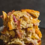 Crispy vegetable and ham casserole with cheese, baked to golden perfection, served on a dark plate. Delicious comfort food recipe perfect for family gatherings and dinner.