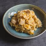 Savory chicken and rice casserole served in a blue ceramic bowl on a dark textured background.