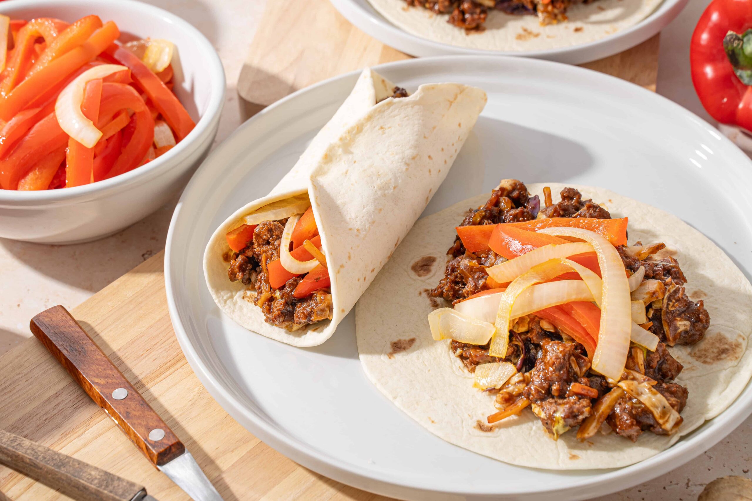 Savory beef taco with sliced onions and peppers on flour tortilla, Mexican street food, authentic homemade taco, delicious filling, restaurant-quality Mexican cuisine.