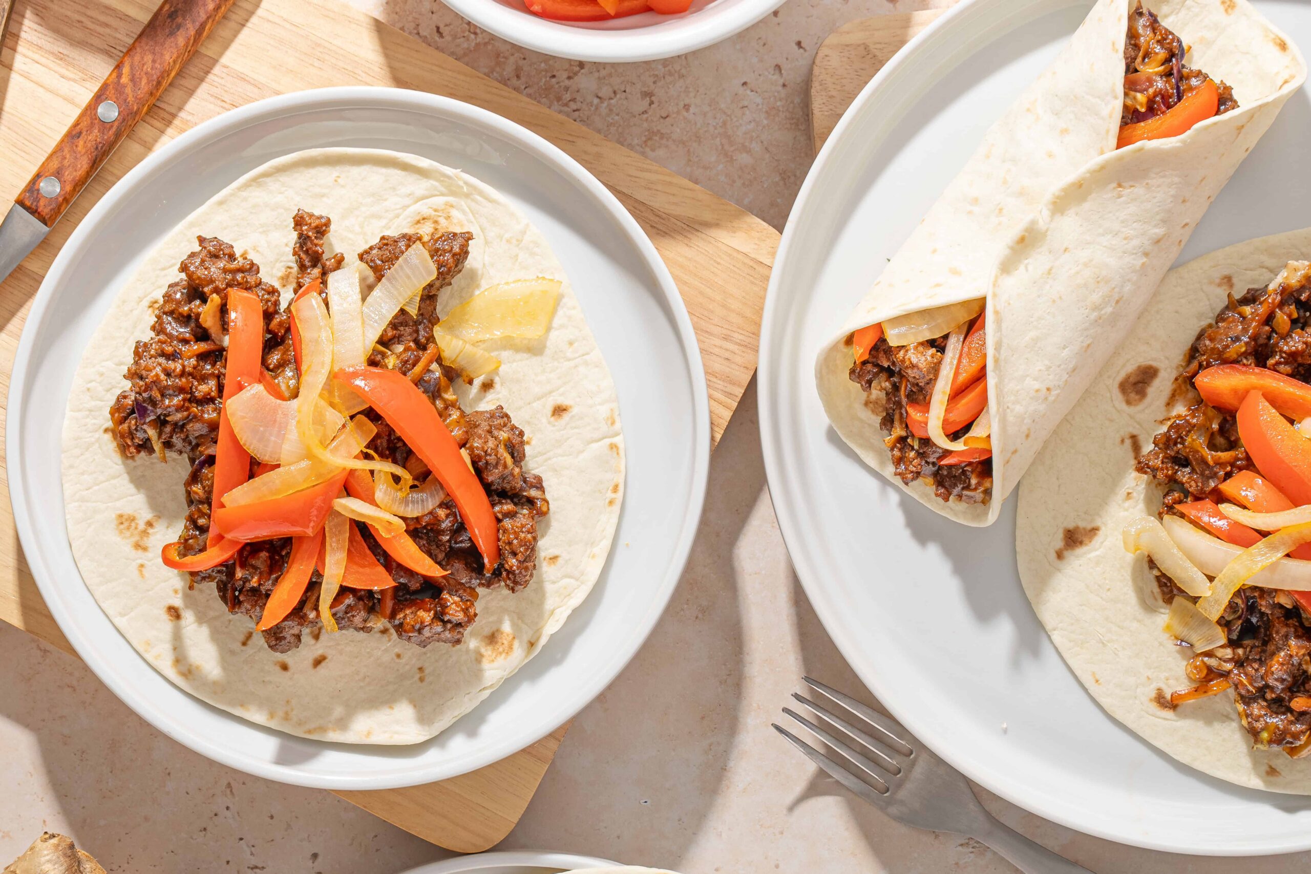 Savory beef taco with colorful vegetables on a soft flour tortilla, served on a white plate, ready for dinner or lunch.