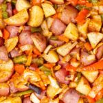 Sauteed hash browns with diced sausage, potatoes, carrots, and bell peppers seasoned with spices; perfect for breakfast or brunch.