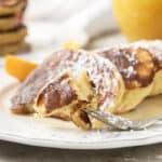Fluffy French toast garnished with powdered sugar, served with orange slices on a white plate, perfect for breakfast or brunch. A delicious, easy-to-make recipe from HeyRecipe.