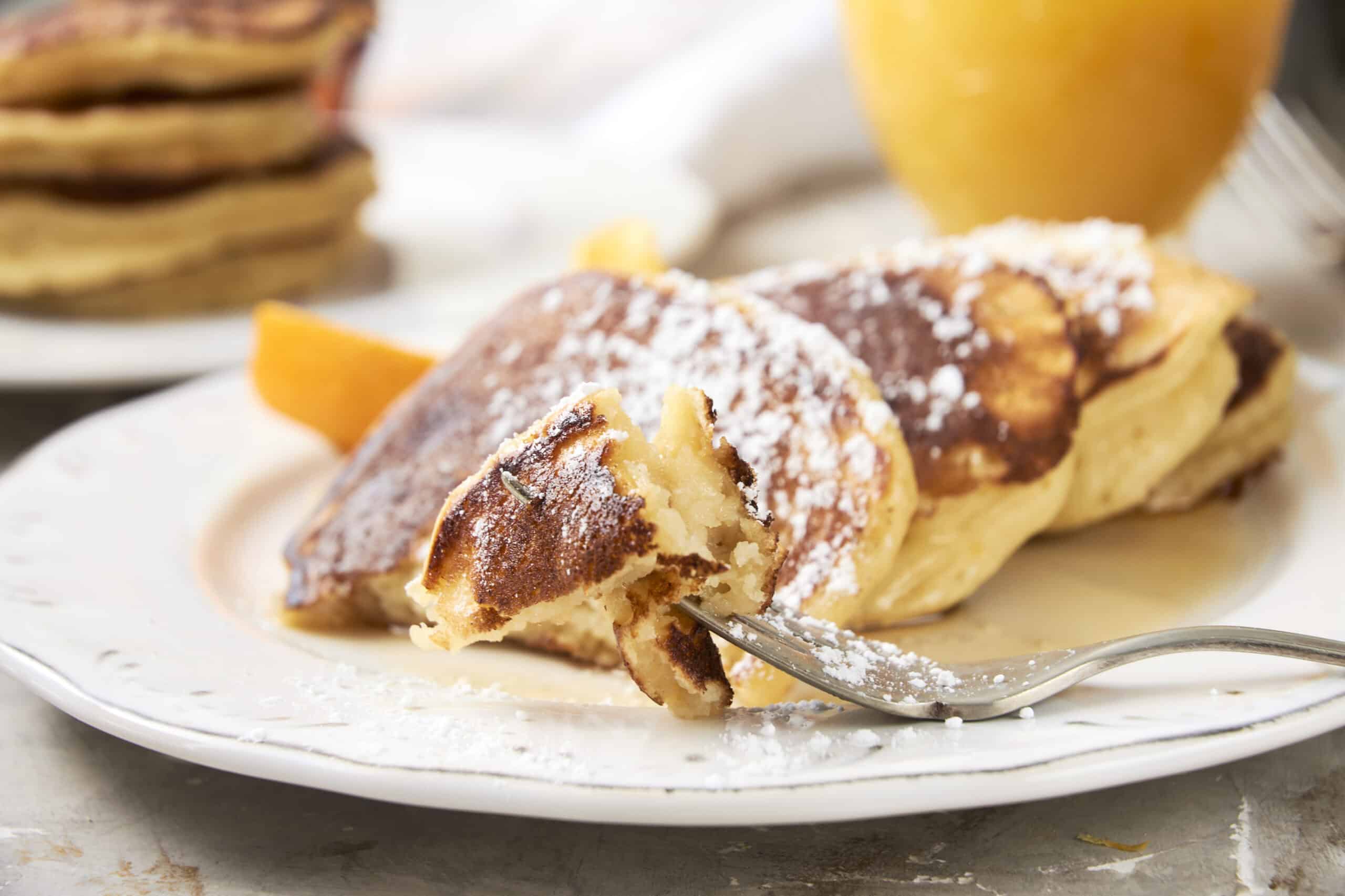 Fluffy French toast garnished with powdered sugar, served with orange slices on a white plate, perfect for breakfast or brunch. A delicious, easy-to-make recipe from HeyRecipe.