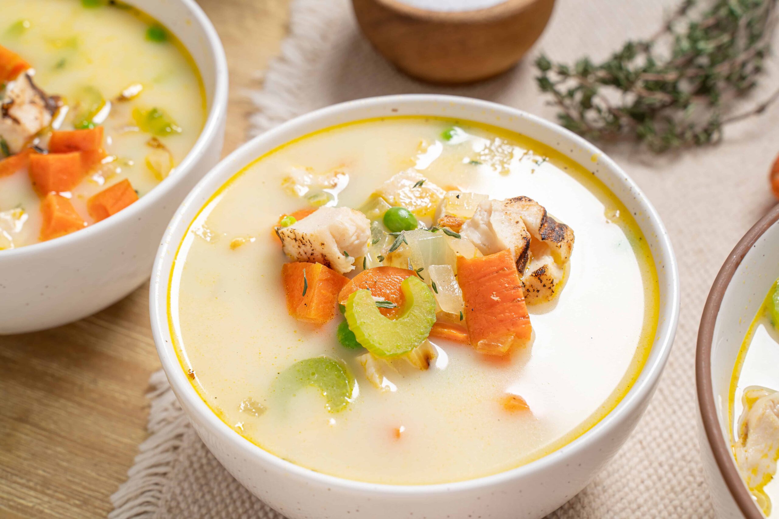 Creamy vegetable chicken soup with carrots, celery, and tender chicken pieces in a white bowl. Perfect for cozy meals and healthy eating, easy to make at home.