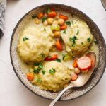 Creamy chicken and vegetable pot pie served in a rustic bowl with chopped parsley garnish.