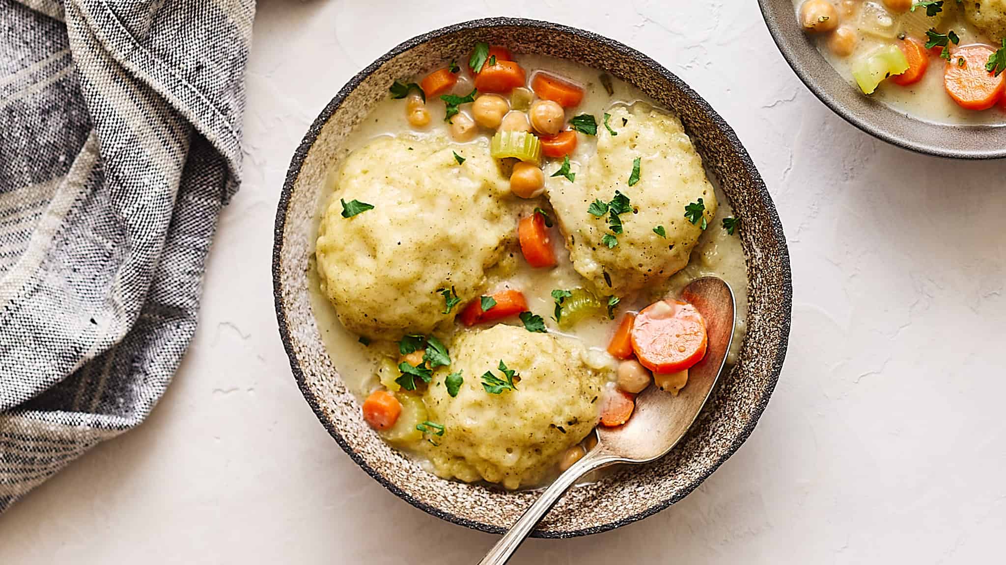 Creamy chicken and vegetable pot pie served in a rustic bowl with chopped parsley garnish.