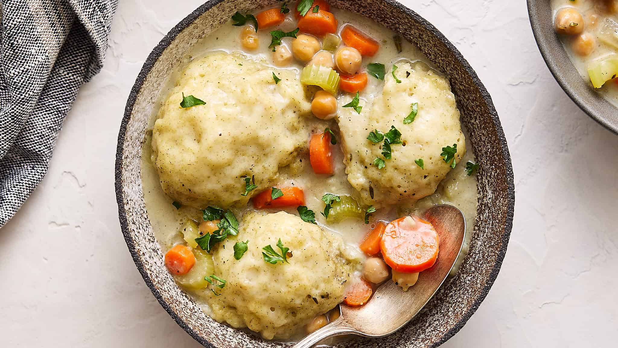 Creamy chicken and vegetable pot pie with tender chicken, carrots, and celery in a savory sauce, served in a rustic black skillet garnished with fresh herbs for a comforting homemade meal.