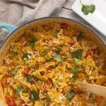 Comforting ground turkey chili with pasta, topped with shredded cheese and fresh cilantro in a rustic skillet. Perfect for cozy dinners and easy weeknight meals.