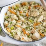 Savory chicken and vegetable fried rice served in a white enamel bowl, garnished with herbs, featuring diced chicken, rice, carrots, and celery, perfect for quick, easy, and delicious homemade meals.