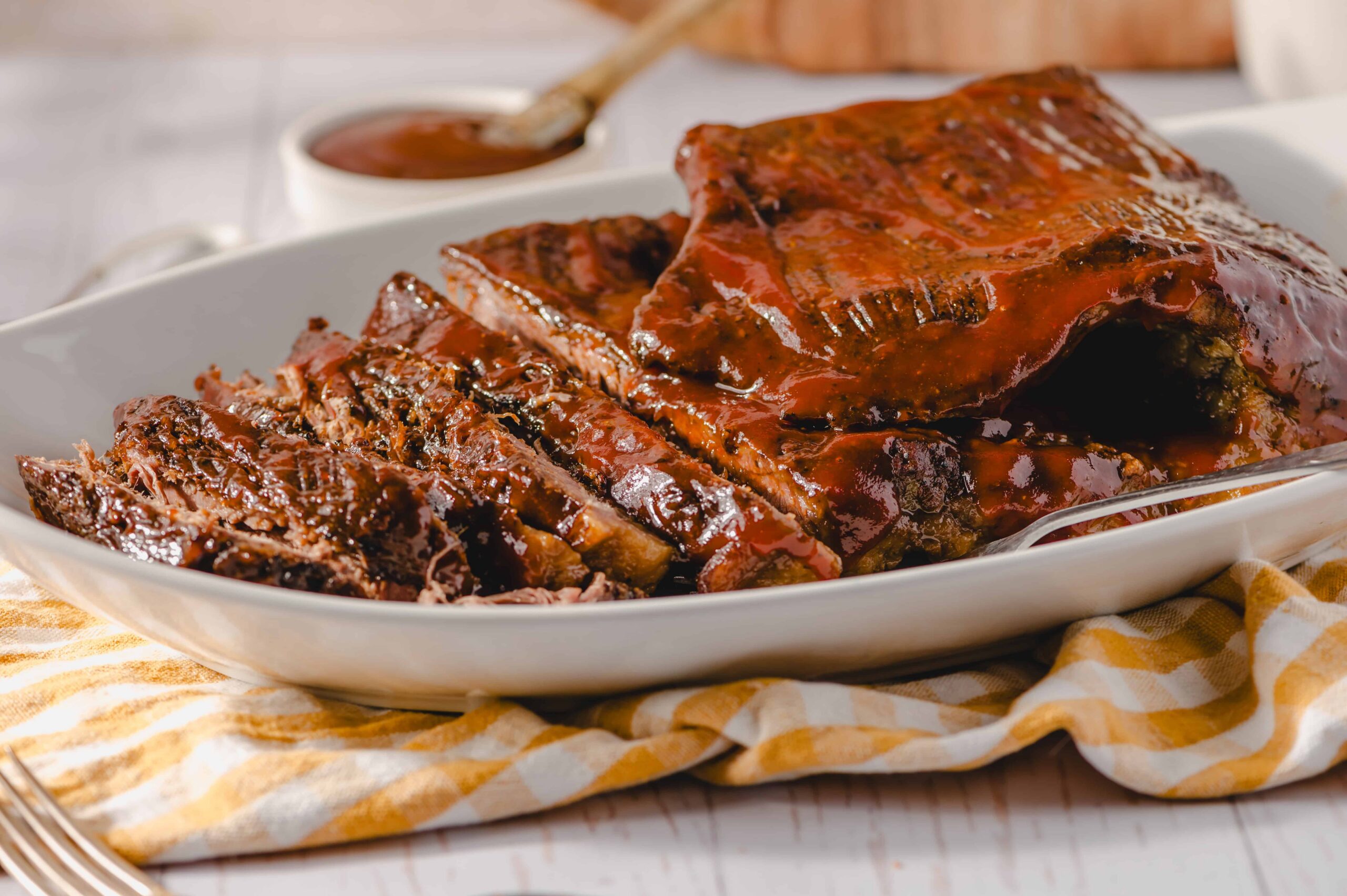 Slow-cooked barbecue ribs with rich, glossy sauce served in a white dish, ideal for family dinner, barbecue parties, and meat lovers. Perfectly cooked tender ribs with flavorful glaze.