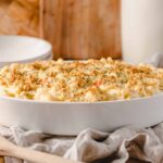 Creamy macaroni and cheese casserole topped with breadcrumbs in a white baking dish. Perfect comfort food, easy to make, and family-friendly classic pasta dish.