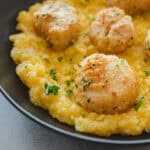 Juicy, seasoned chicken meatballs served over creamy mashed potatoes garnished with chopped parsley. Perfect comfort food dish that combines savory flavors and smooth texture for a satisfying meal.