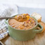 Hearty bowl of homemade beef and corn chowder with creamy broth, vegetables, and tender beef chunks served in a rustic mug. Perfect comfort food for cold days.