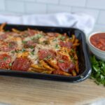 Delicious homemade baked ziti pasta with pepperoni, melted cheese, and fresh herbs served with marinara sauce on the side. Perfect for family dinner or casual gatherings.