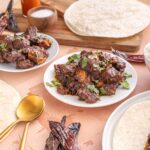 Savory Mexican-style beef and pork stew served with warm tortillas, rice, and dried chili peppers, showcasing traditional ingredients and flavors for authentic Mexican cuisine.