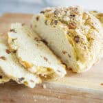 Butter cake with chopped nuts and dried fruits on wooden cutting board, close-up view, homemade dessert, sweet baked good, comforting treat, delicious homemade cake, ingredient-focused photo, appealing bakery-style treat, perfect for snack or celebration, cozy baking at home.