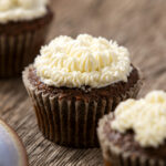 Rich chocolate cupcakes topped with creamy vanilla buttercream frosting, perfect for desserts or special occasions. These moist cupcakes are decorated with elegant piped frosting, showcasing a delectable treat from Hey Recipe.