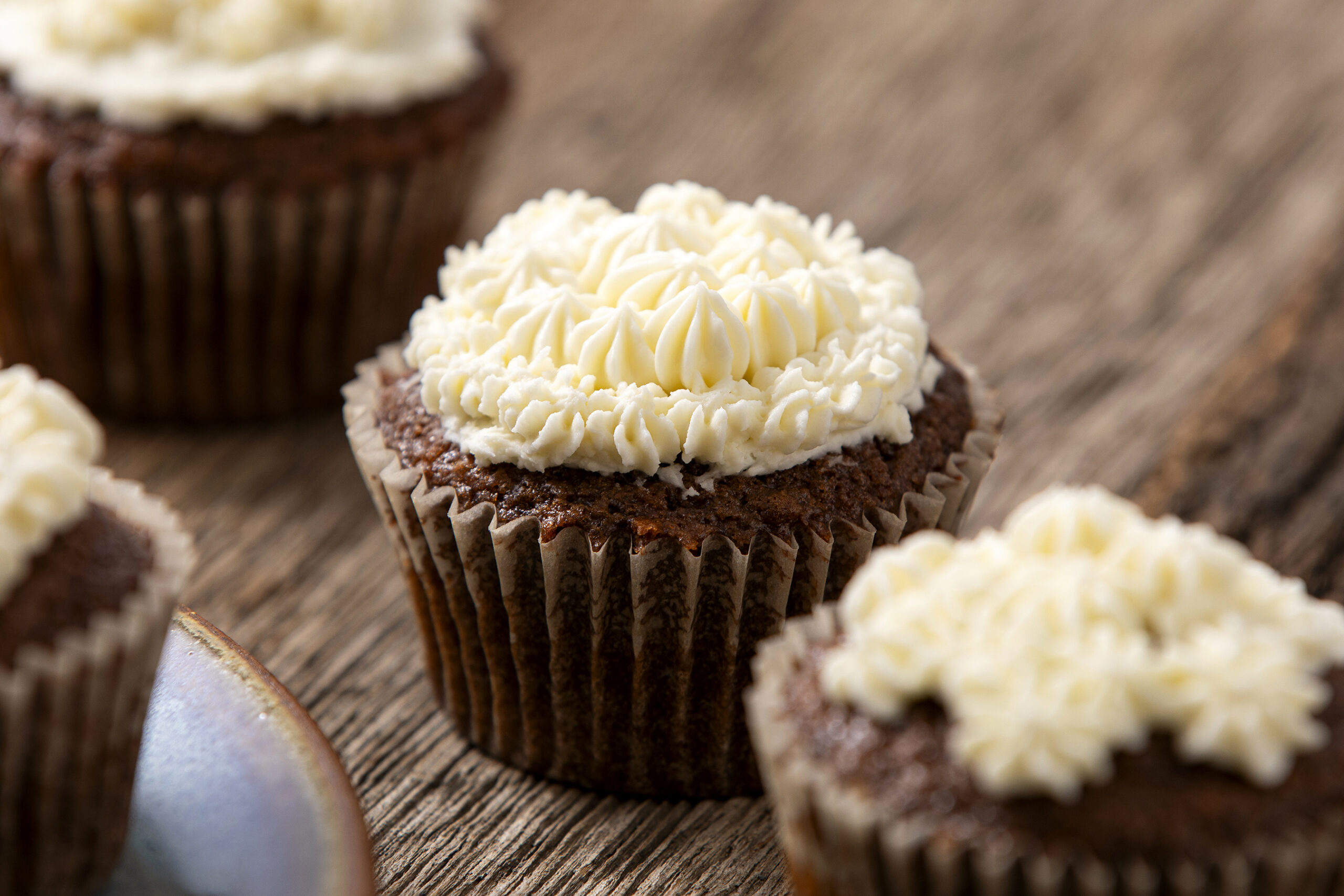 Rich chocolate cupcakes topped with creamy vanilla buttercream frosting, perfect for desserts or special occasions. These moist cupcakes are decorated with elegant piped frosting, showcasing a delectable treat from Hey Recipe.