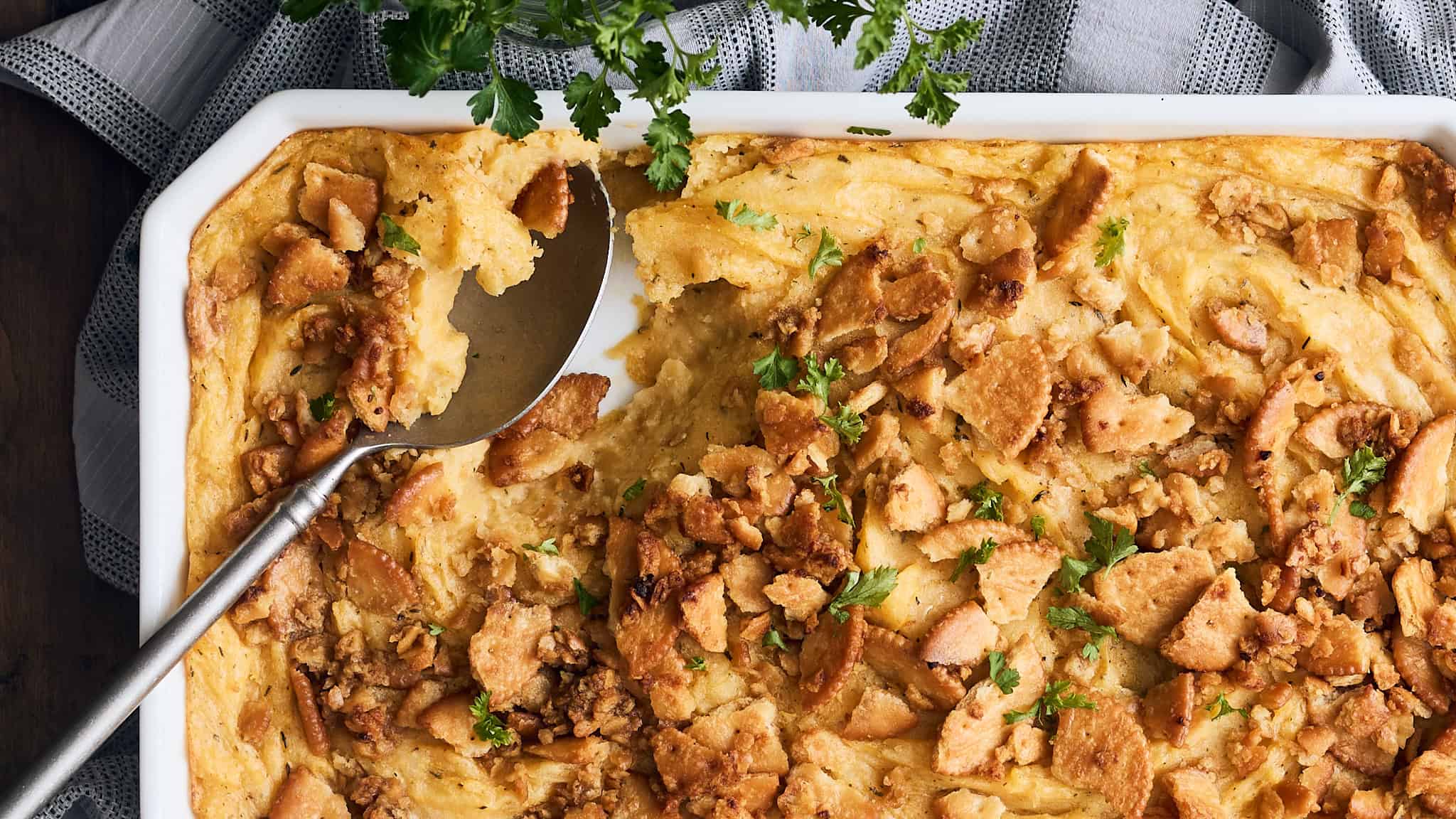 Savory chicken pot pie with flaky crust and golden-brown chicken filling, garnished with fresh herbs, served in a white casserole dish.