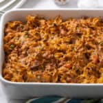 Creamy baked pasta casserole with cheese, vegetables, and meat, served in a white baking dish, perfect for comfort food and family dinner recipes.