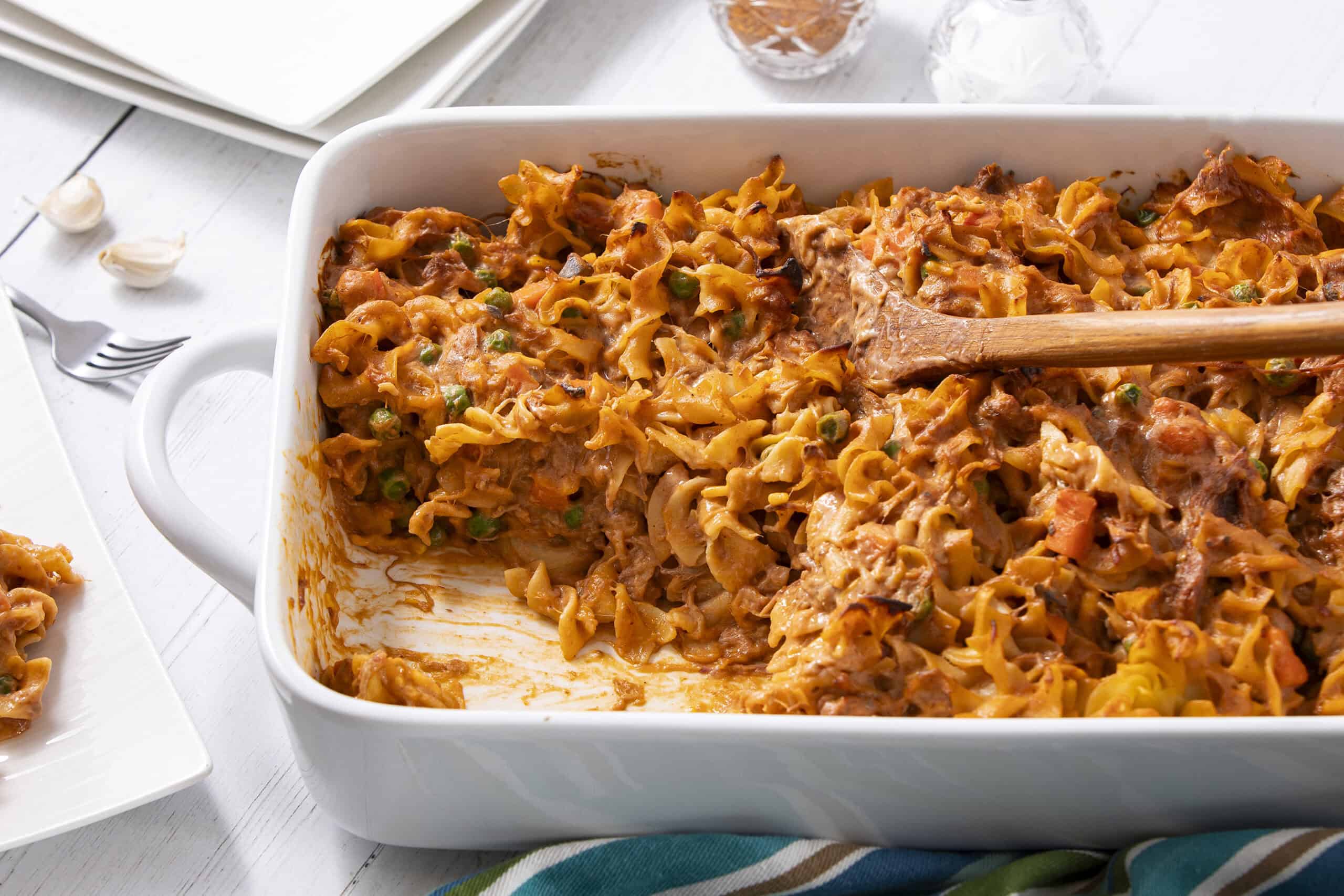 Creamy chicken casserole with noodles, vegetables, and flavorful sauce in a white baking dish, ready to serve.