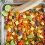 Sautéed chicken and mixed vegetables in a flavorful sauce topped with pineapple chunks, lime wedges, and fresh cilantro on a baking sheet. Perfect for quick, healthy meal recipes and delicious flavorful dinners.