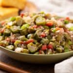Freshly prepared okra salad with diced vegetables, herbs, and a light seasoning, served in a green bowl. Perfect for healthy, flavorful meals or side dishes during summer or family gatherings.
