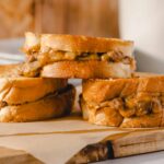 Hearty grilled cheese sandwiches with melted cheese and savory fillings on toasted bread, perfect for comfort food lovers.