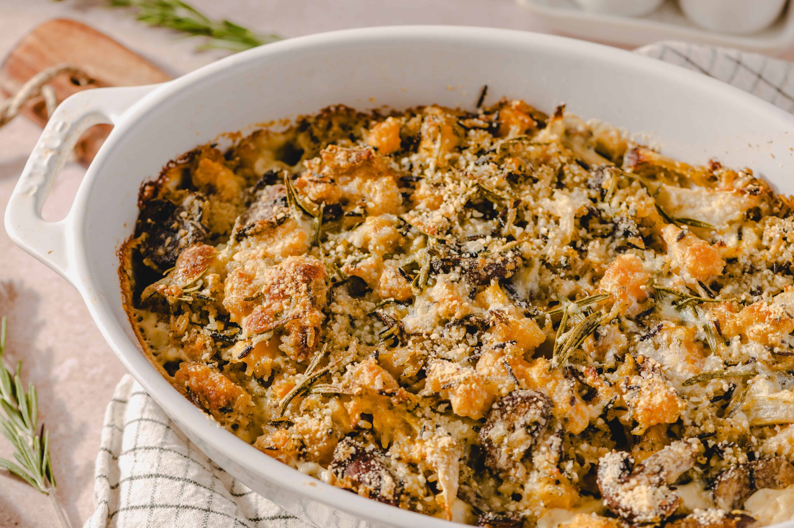 Baked vegetable and cheese casserole topped with breadcrumbs and herbs in a white ceramic baking dish, ready to serve.